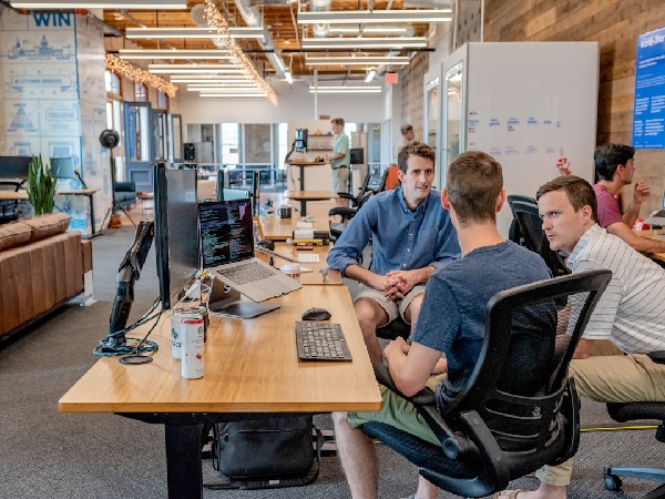 Three men discussing what an open source proposal management software is